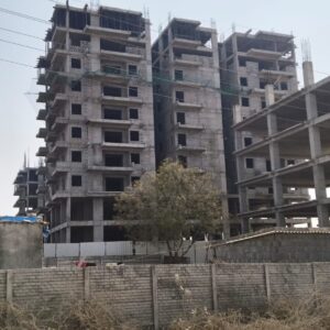 a building under construction with a tree and a fence