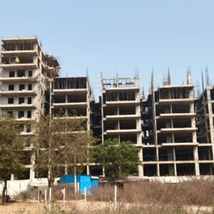 a building under construction with trees and blue sky